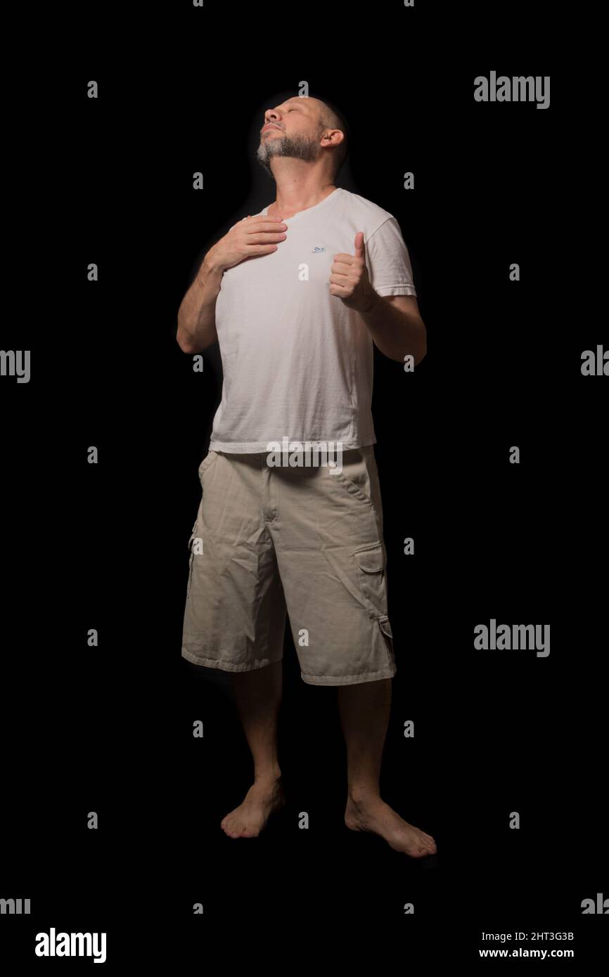 Portrait of a man standing against a black background. Salvador, Bahia, Brazil. Stock Photo