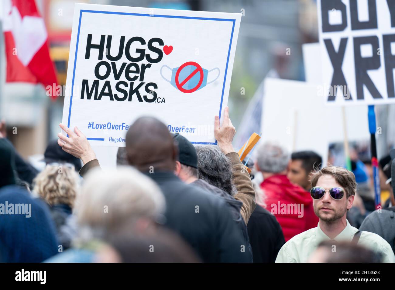 Hugs over masks sign at anti mask protest during Covid-19 rally event in Toronto, Ontario Canada Stock Photo