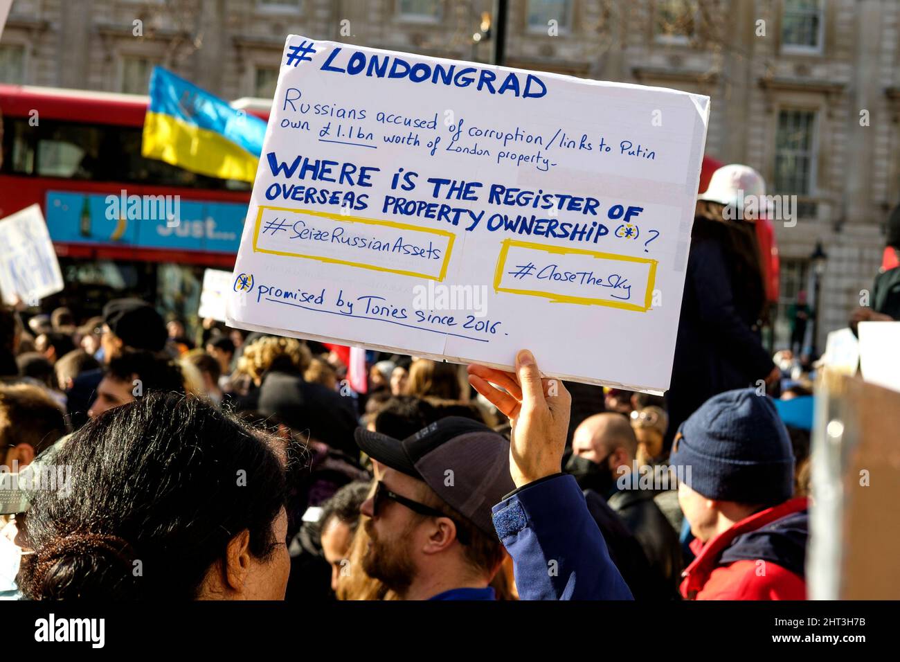 26th February 2022: Ukrainian nationals and pro-Ukraine supporters rally in Whitehall  to protest against the Russian invasion of Ukraine. London, United Kingdom. Pictured: A protester holds a placard criticising the UK government's failure to act against Russian citizens' assets in London. Stock Photo