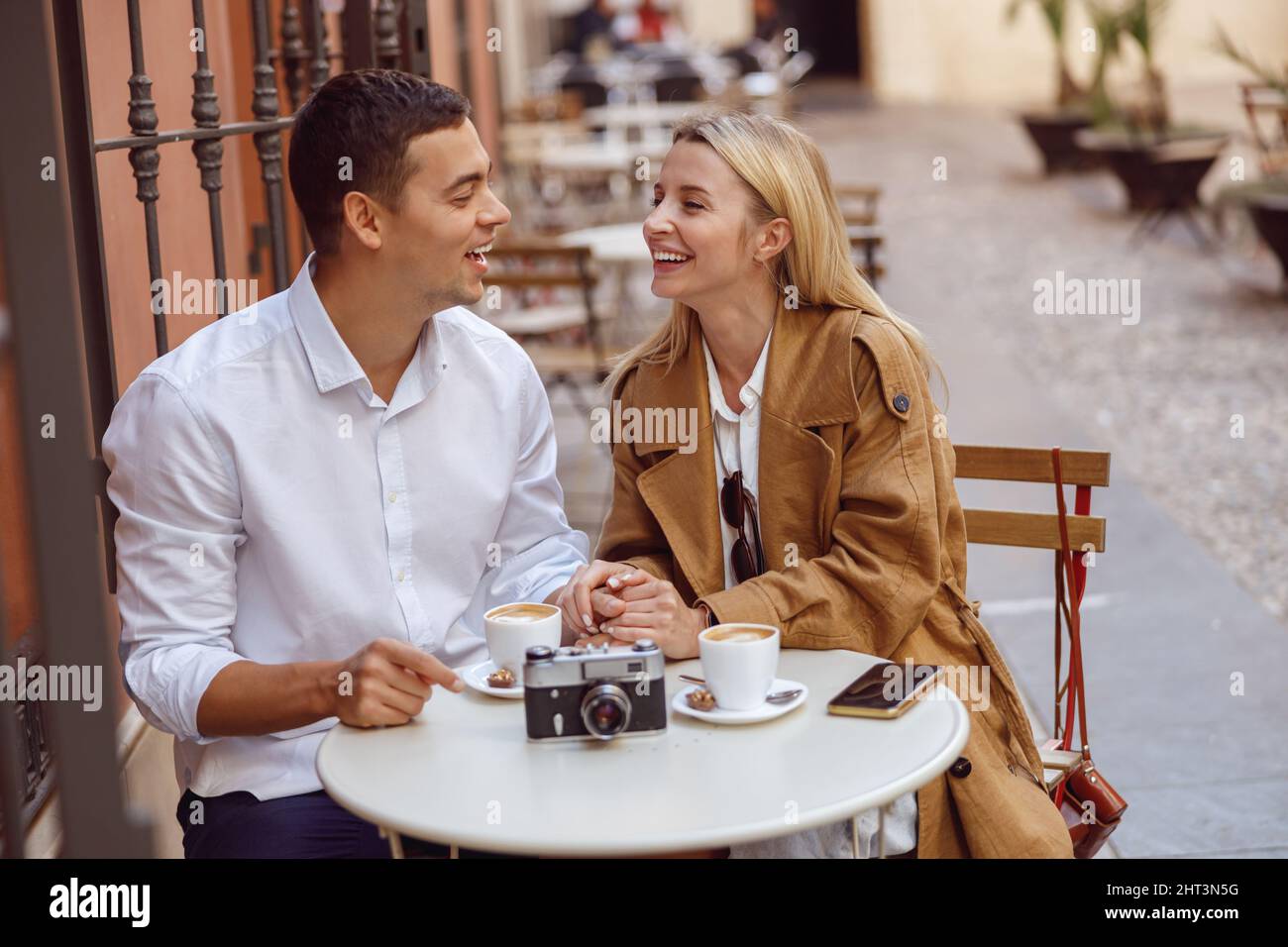 Couple laughing while sitting at cafe table during date Stock Photo