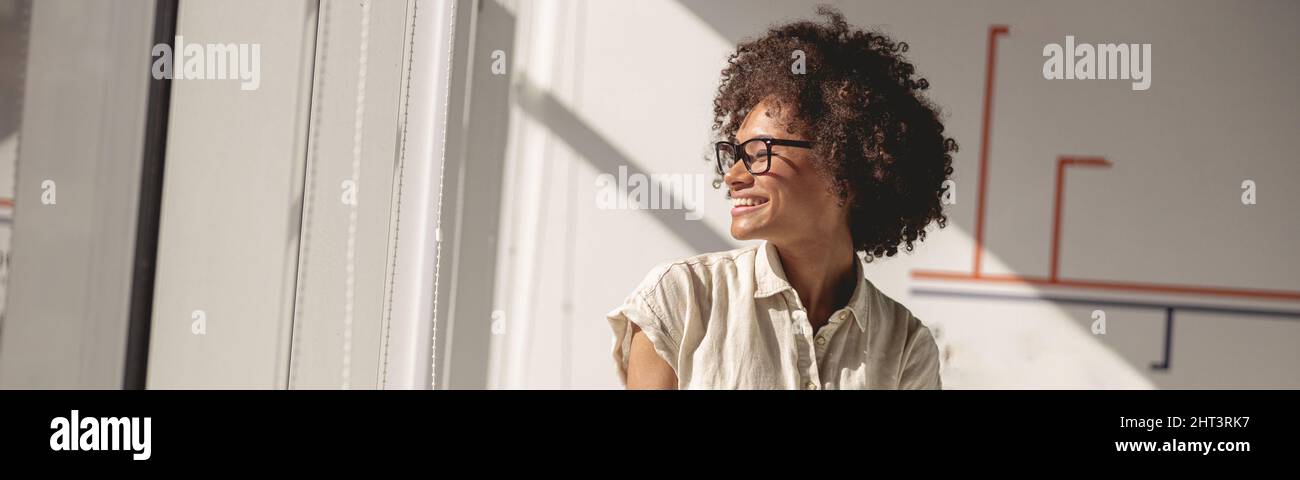 Pretty multiethnic lady sitting at work desk in the office Stock Photo