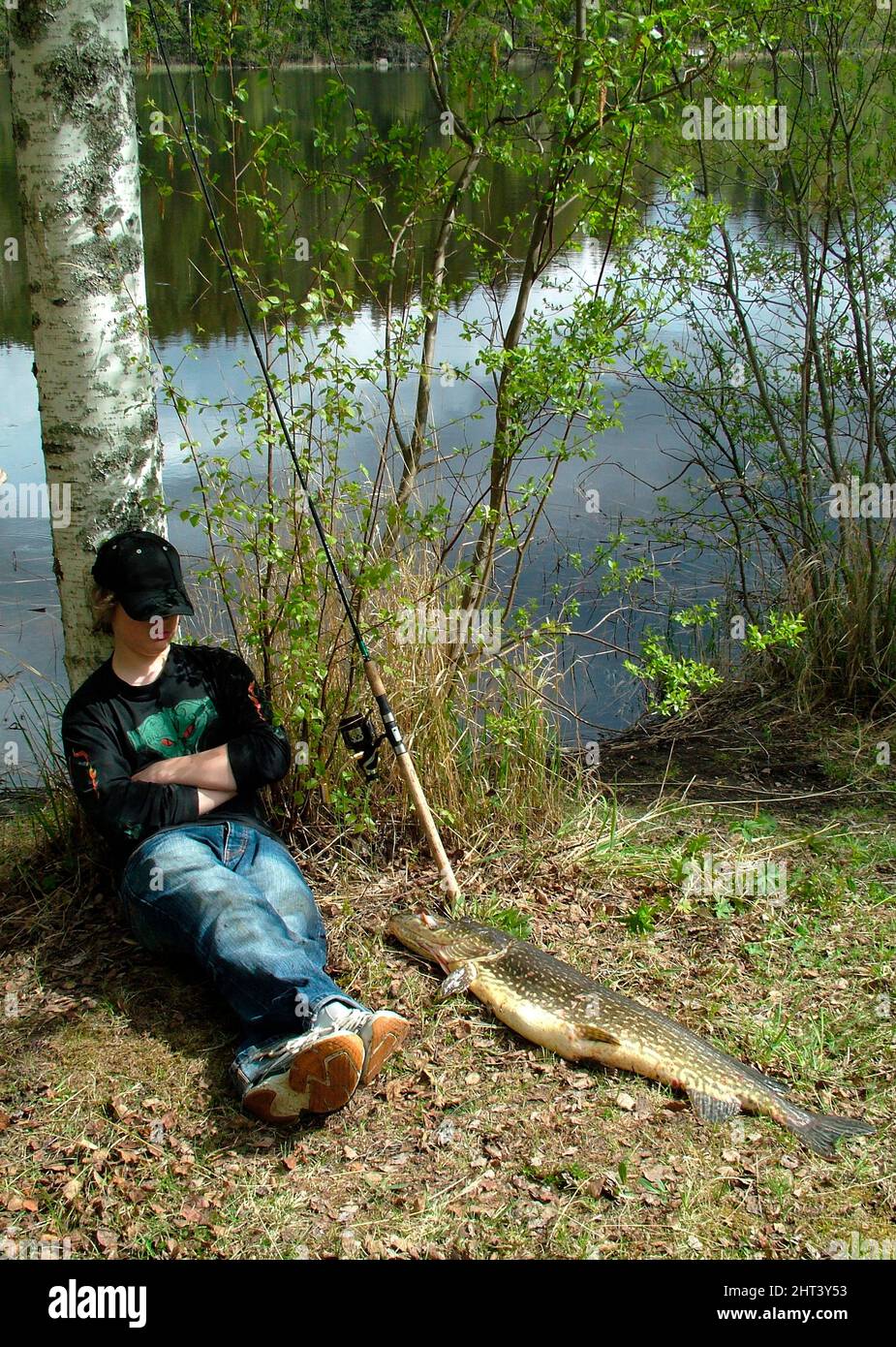 Boy take a fishing break by birch Stock Photo - Alamy
