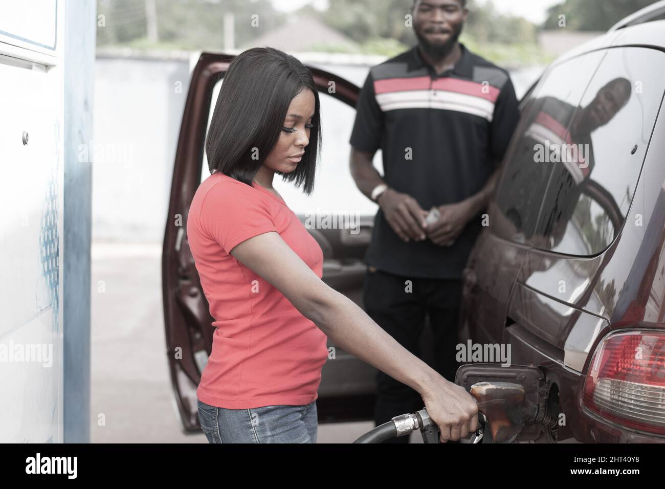 African petrol station attendant filling up a car Stock Photo - Alamy