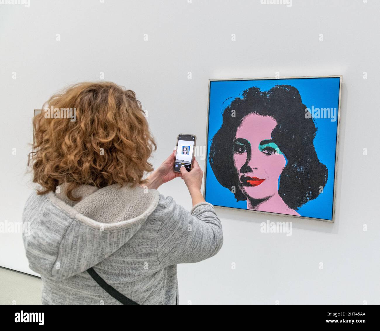 Los Angeles, CA, USA - February 25, 2022: A visitor to The Broad museum takes a picture of the painting “Liz” by artist Andy Warhol in downtown Los An Stock Photo