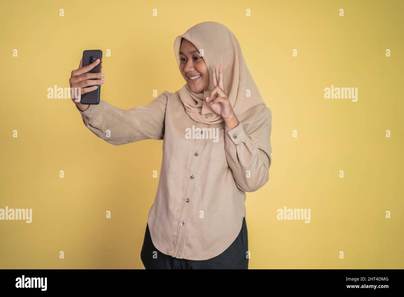 Asian woman in hijab holding a smart phone for selfie Stock Photo - Alamy