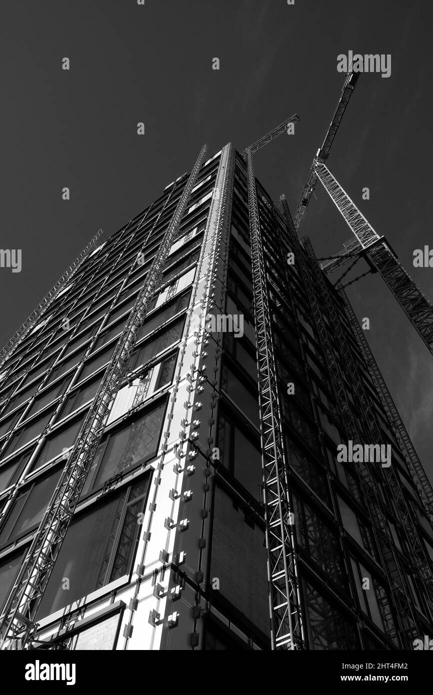 Grayscale of a modern high-rise building in the shell with construction crane in Frankfurt am Main Stock Photo
