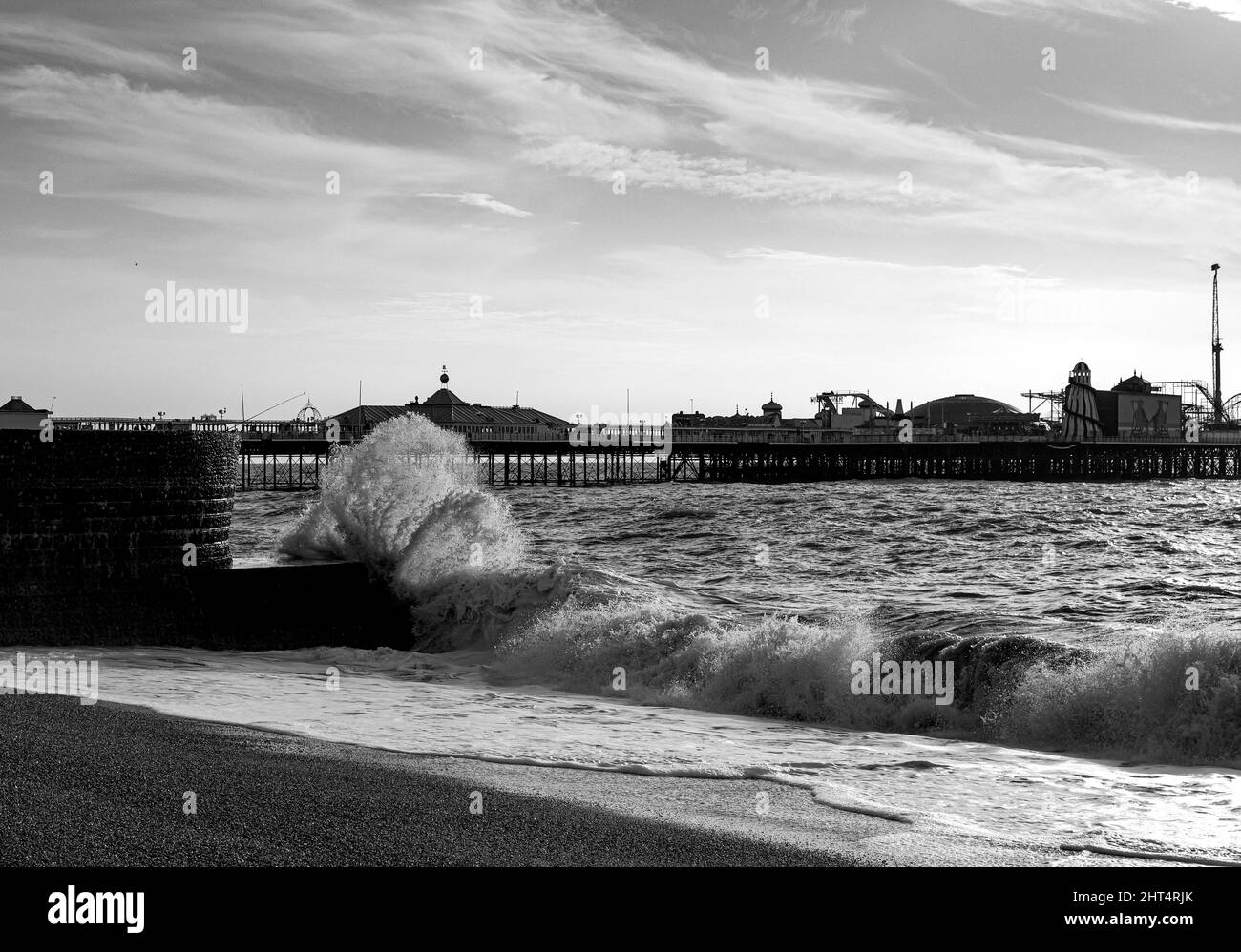 Grayscale shot of the Brighton Palace Pier over the sea on a rainy day in the UK Stock Photo