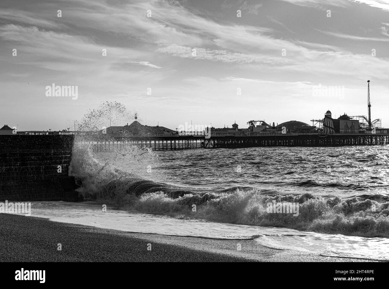 Grayscale shot of the Brighton Palace Pier over the sea on a rainy day in the UK Stock Photo