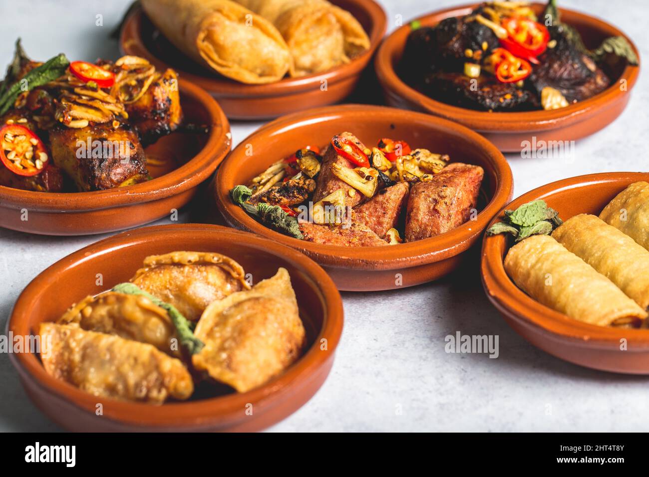 An assortment of tasty and appetizing dishes in clay bowls Stock Photo