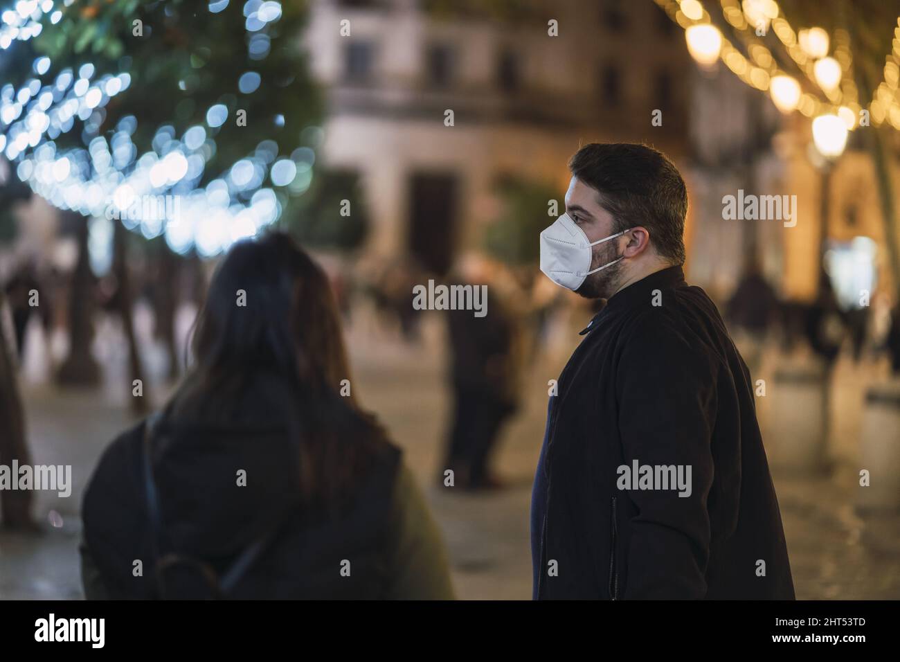 Couple wearing facemask while walking at the street in Spain Stock