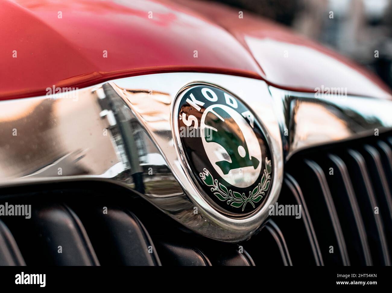 Black and chrome trim around Skoda logo on front of red car Stock Photo