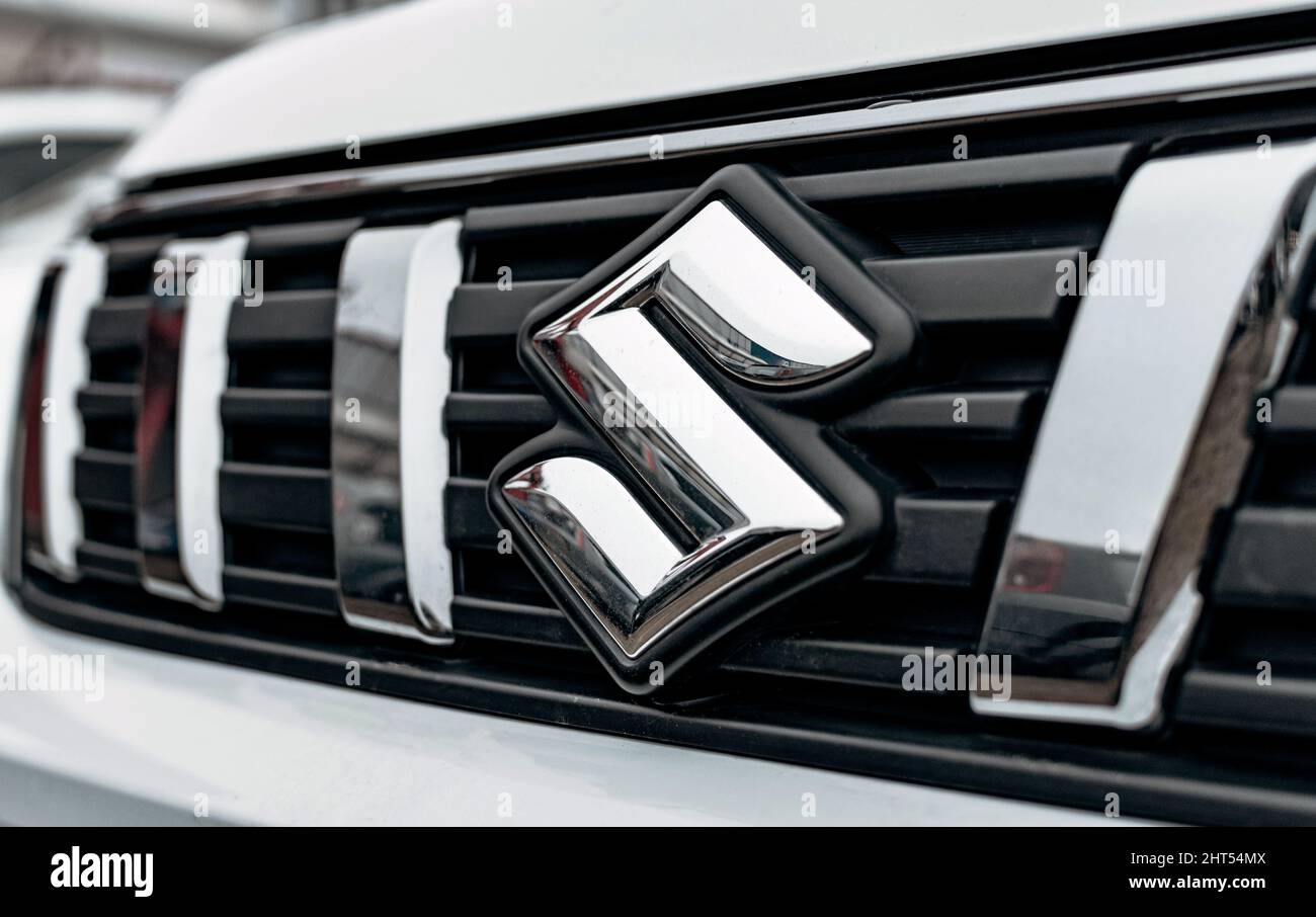 Black and chrome trim around Suzuki logo on front of a silver car Stock Photo