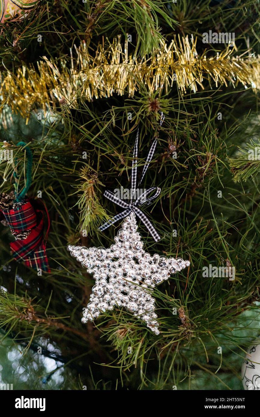 Vertical shot of a silver star hung from the Christmas tree Stock Photo ...