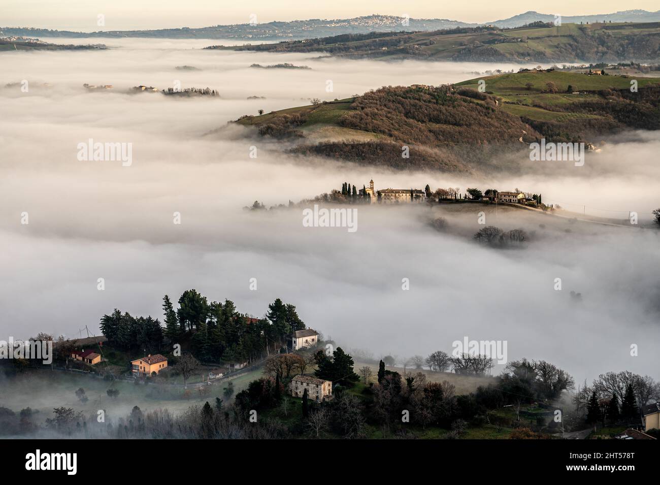 A view of the medieval village of Montecarotto di Arcevia immersed in the fog Stock Photo