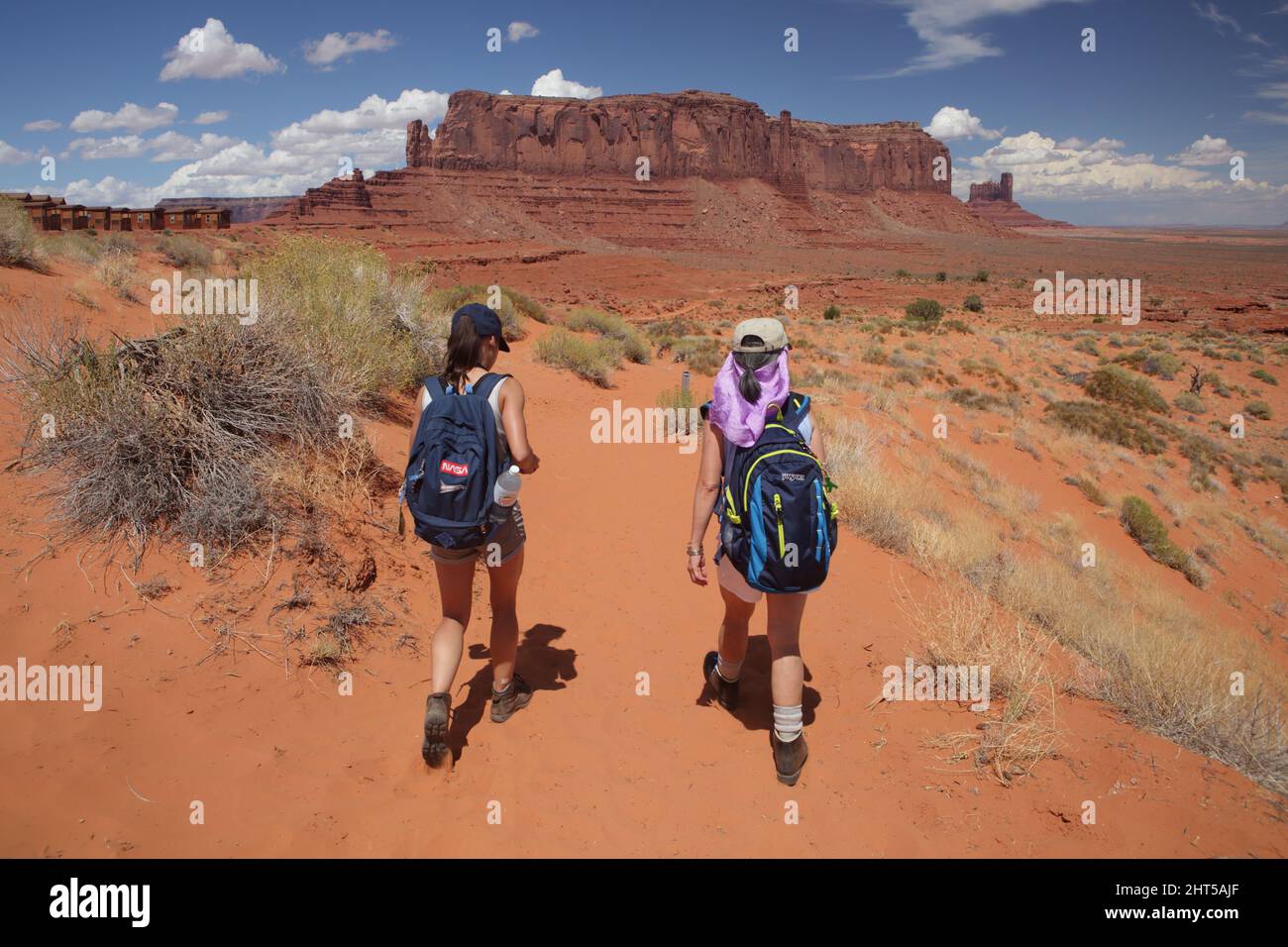 Hiking the Wildcat Trail in Monument Valley Navajo Tribal Park, USA. A hot august day with blue sky and sandstone cliffs, buttes, and pinnacles. Stock Photo