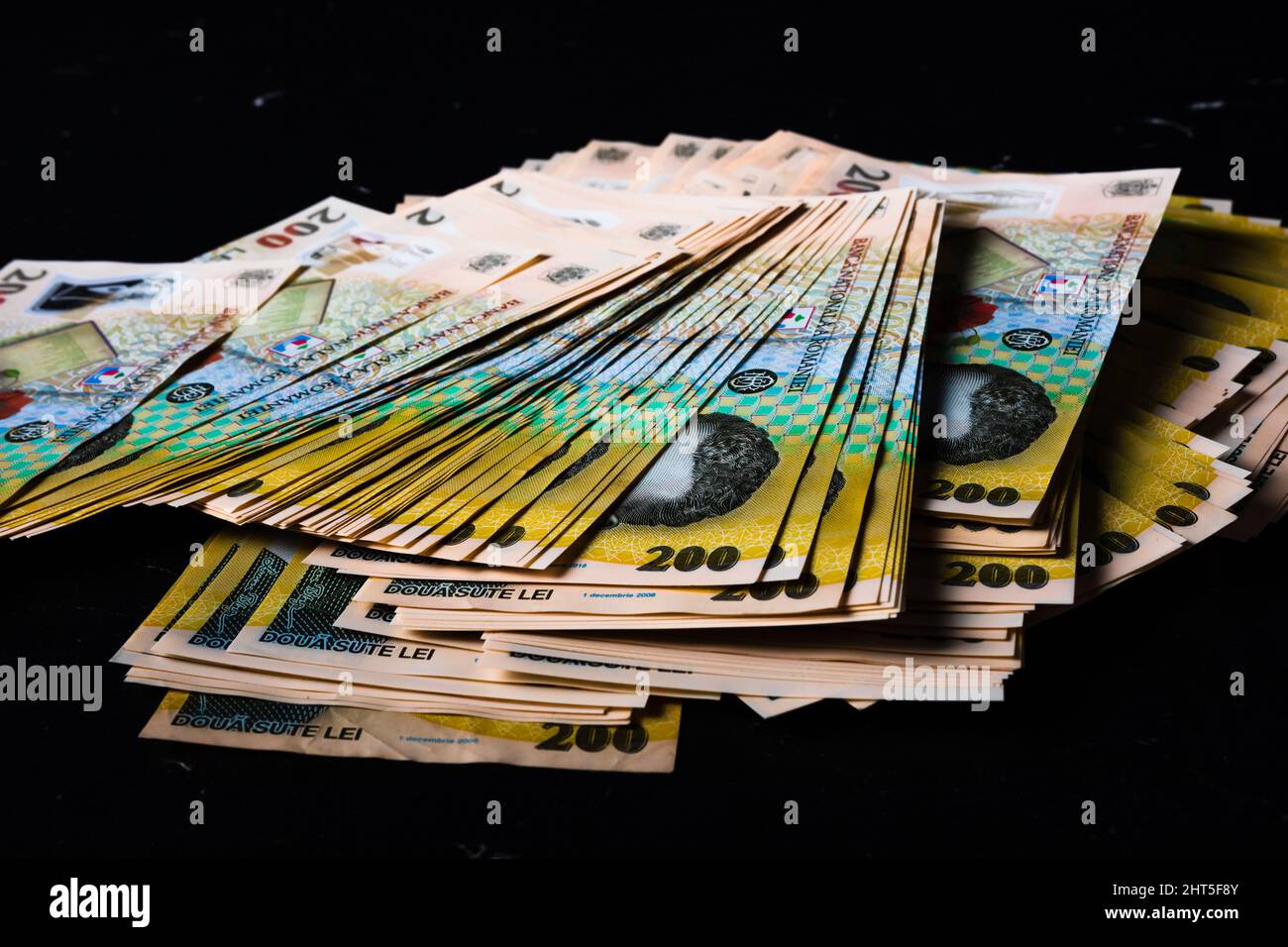 Closeup shot of 200 lei banknote stacks on a black surface Stock Photo ...