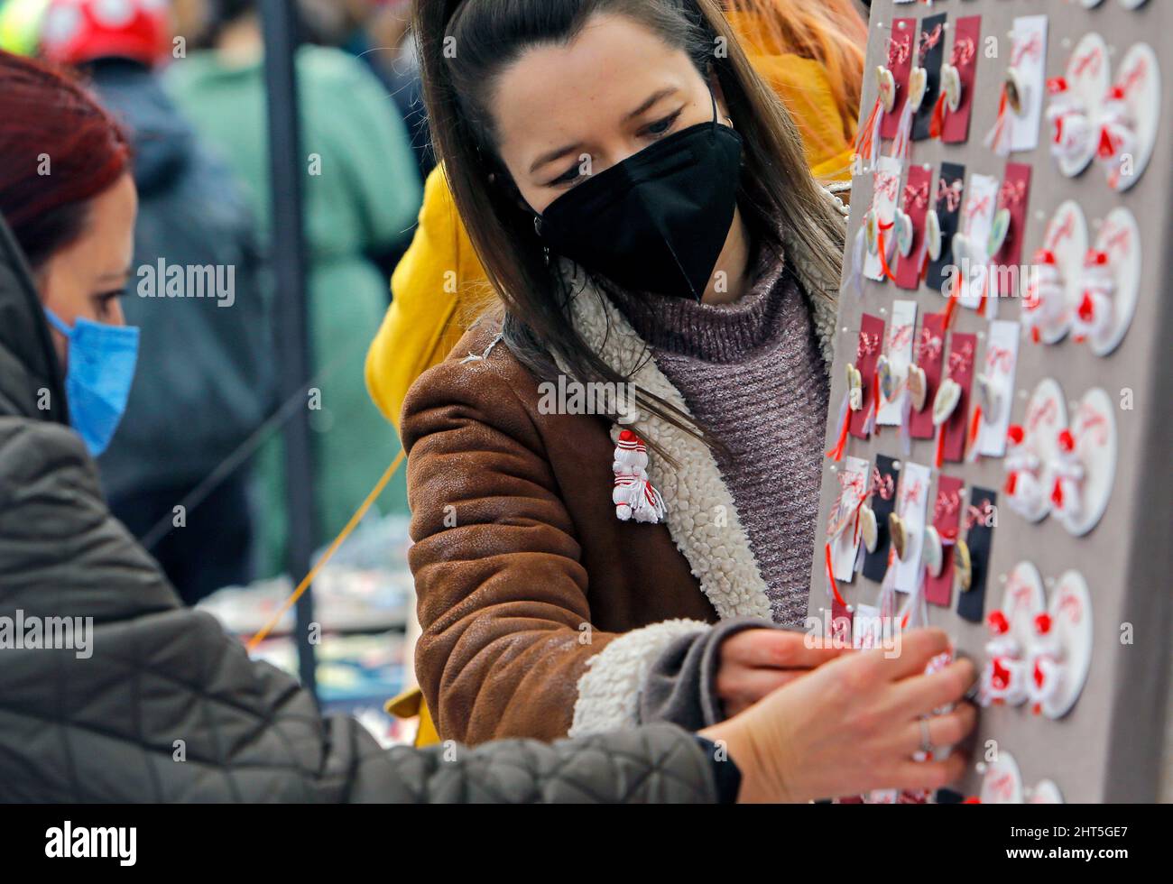 Bucharest, Romania. 26th Feb, 2022. People look at small handmade figurines called 'Martisor' during the 'Martisor Fair' in Bucharest, capital of Romania, Feb. 26, 2022. Martisor is a small decoration tied with a red-and-white twisted string, given to women on the 1st of March as a token of appreciation, love or friendship and as a wish of health, being at the same time a symbol of the coming spring. Credit: Cristian Cristel/Xinhua/Alamy Live News Stock Photo