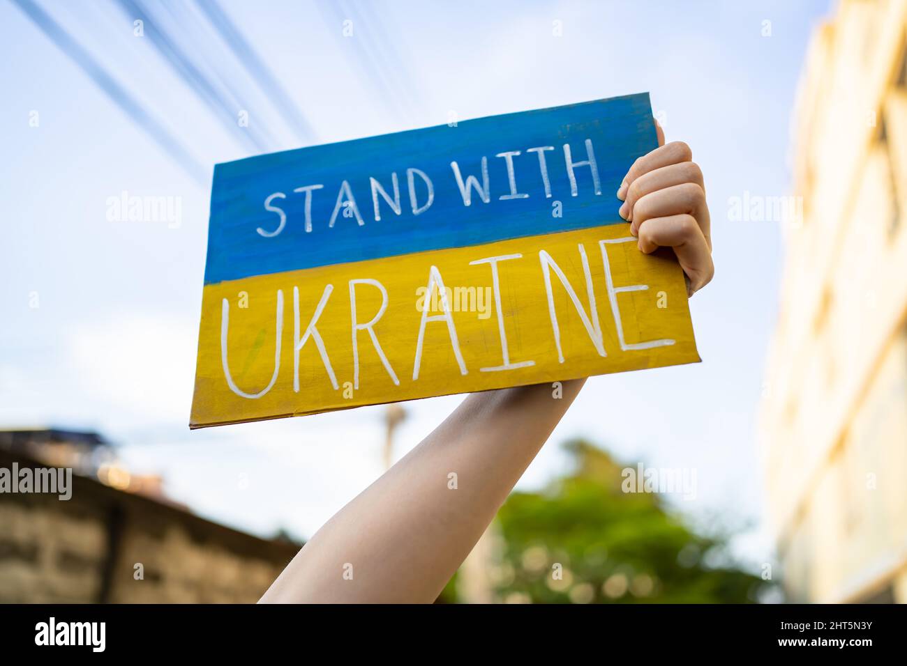 Demonstrator holding "Stand with Ukraine" placard Stock Photo