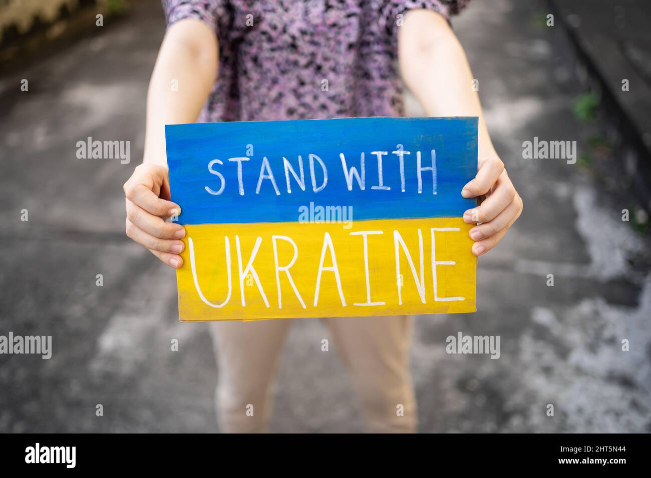 Demonstrator holding 'Stand with Ukraine' placard Stock Photo