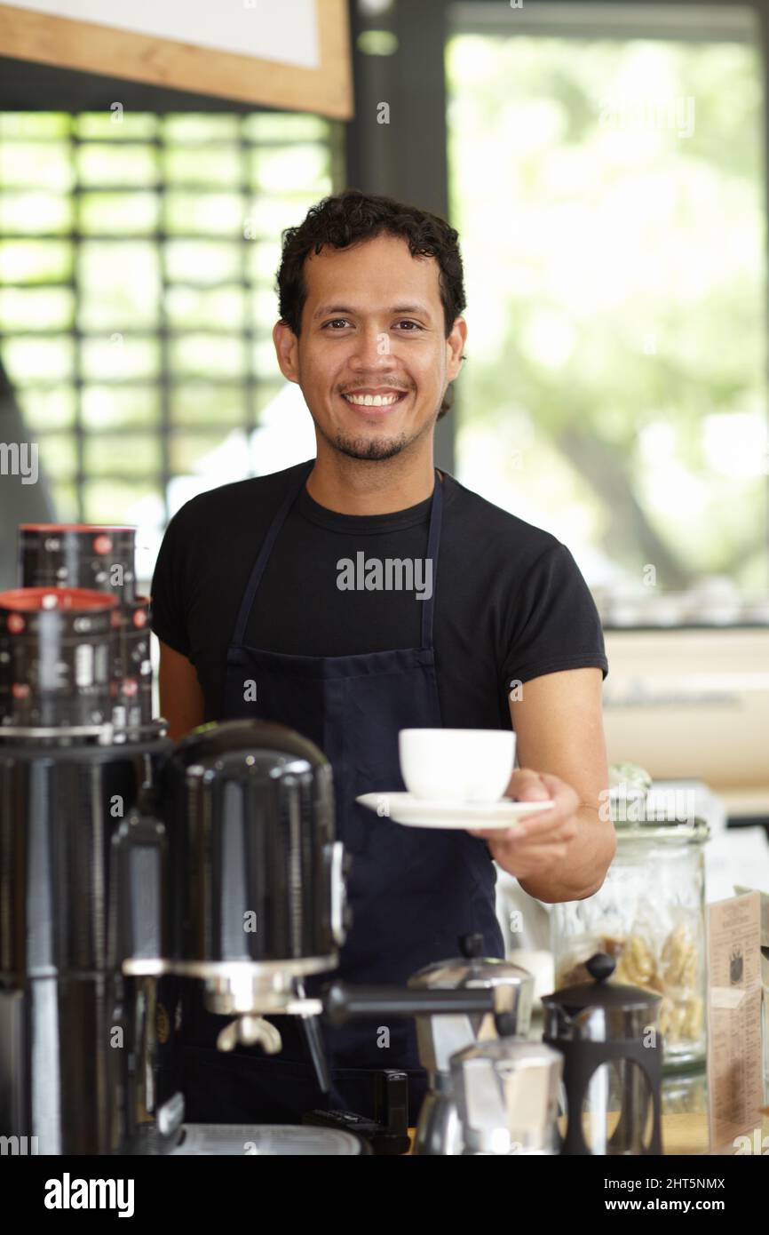 Fancy a fresh cup of joe. Shot of a handsome barista serving up a fresh