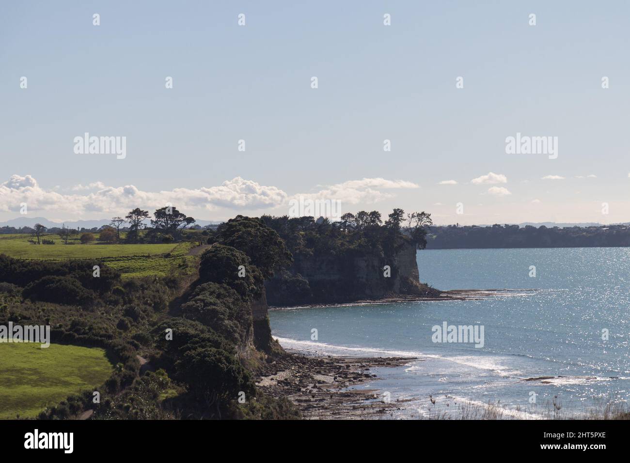 The view of green field, cliff and blue sea on background, Long Bay