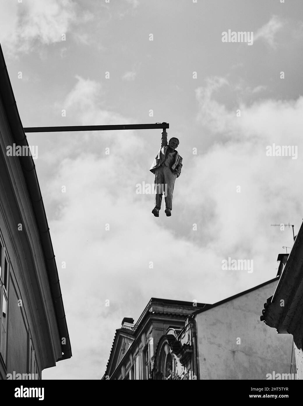 Vertical shot of the Hanging Man statue in black and white in Prague