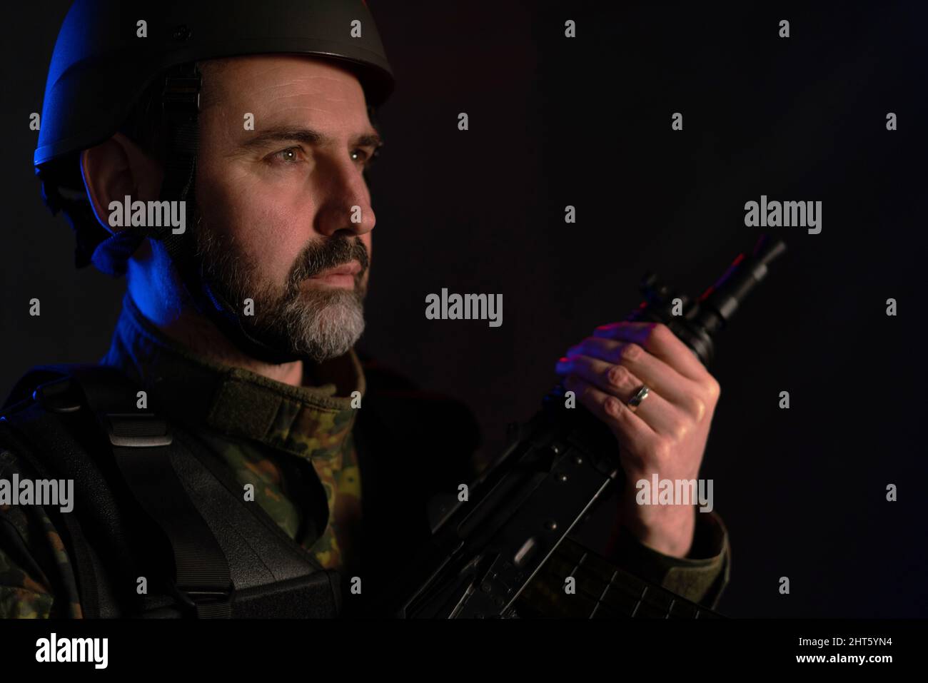 A soldier in military uniform and helmet with weapon on black ...