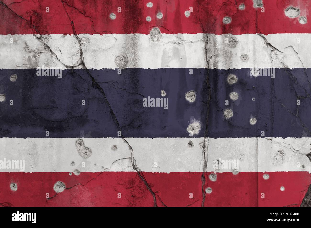 Full frame photo of a weathered flag of Thailand painted on a cracked wall with bullet holes. South Thailand insurgency concept. Stock Photo