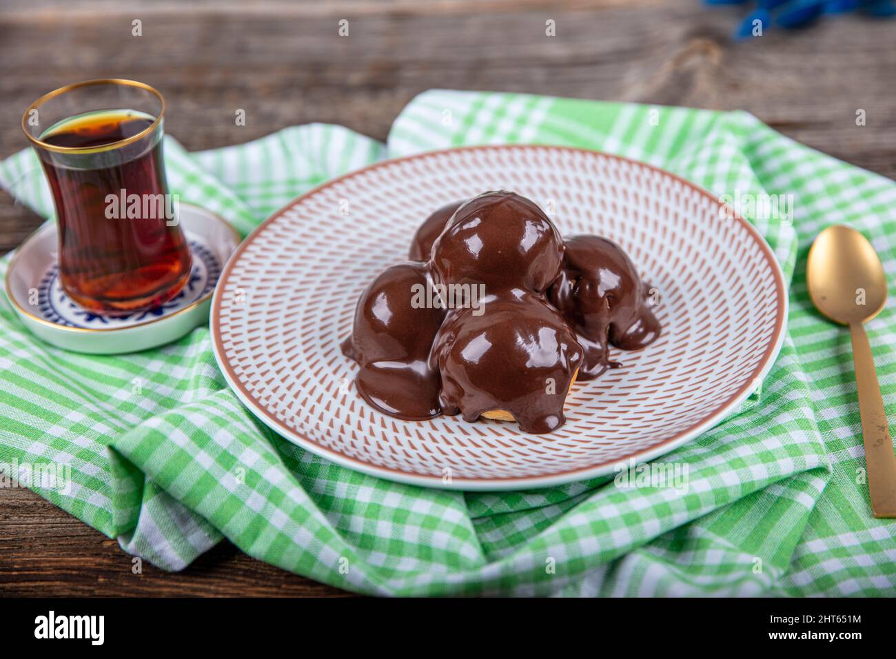Delicious profiteroles with chocolate and plate. Delicious profiteroles