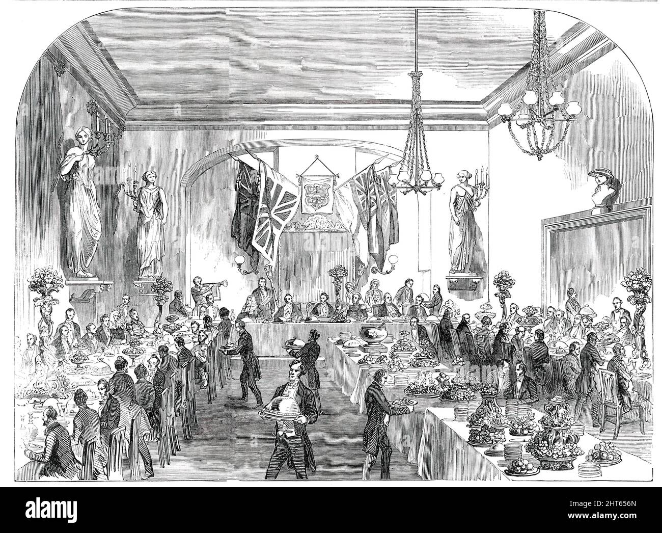 Grand Banquet to the Lord Mayor of London, at Hastings, [Sussex], 1850. 'The banquet took place in an elegant room, embellished with statues of the Muses. On a table, in the centre of the room, stood...the vast silver punch-bowl presented by the Barons who attended the coronation of King George II. and Queen Caroline...The more distinguished of the guests occupied a table...situated on a slightly elevated dais. Behind and above them were the national colours and the corporation arms. [The banquet] was provided by Mr. Carswell, of the Swan Hotel, assisted by Messrs. Ring and Brymer...'. The May Stock Photo