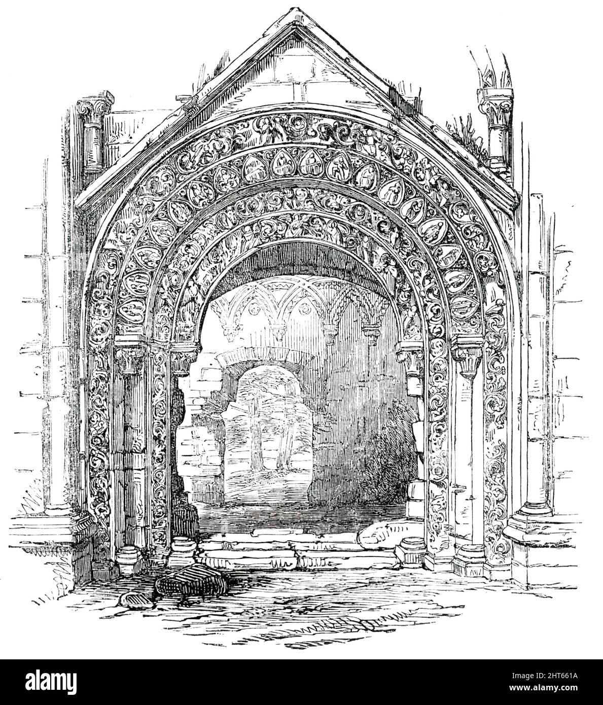 Glastonbury Abbey - North Door of St. Joseph's Chapel, 1850. Ruined medieval abbey in Glastonbury, Somerset. View showing '...the North Portal of St. Joseph's Chapel, than which nothing in freestone masonry can be more highly sculptured. This building is attributed to the abbacy of Hirlewinus, between the years 1102 and 1120. It consists of semicircular arches (four in number), receding gently in succession into the body of the wall, and diminishing in size as they recede, each resting on pillars, and their fasciae thickly covered with a profusion of sculptured representations. We perceive the Stock Photo
