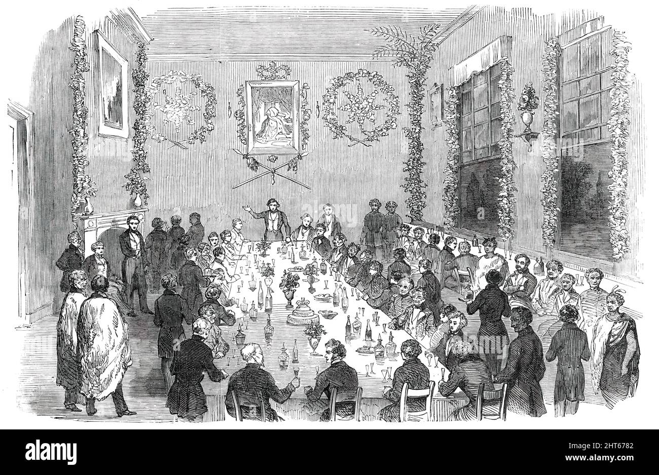 Banquet given at Wellington to Native Chiefs of New Zealand, 1850. '...an Entertainment lately given...by Dr. Fitzgerald...on the occasion of having received from Earl Grey a portrait of her Majesty Queen Victoria...At the head of the apartment, over the chair, was the portrait of her Majesty...Underneath were two splendid native war spears, forming...a triangle, from the apex of which a magnificent &quot;mere pounamia,&quot; or greenstone club, was suspended; these, being emblems of New Zealand chieftainship, were intended to represent the cession of sovereignty to her Majesty the Queen. On e Stock Photo