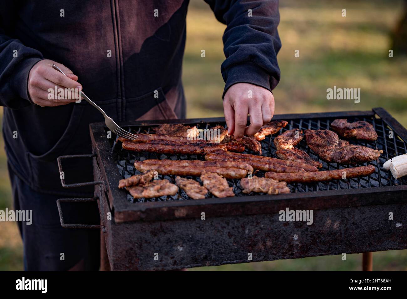Closeup shot of some meat and sausages being grilled in a park Stock Photo  - Alamy