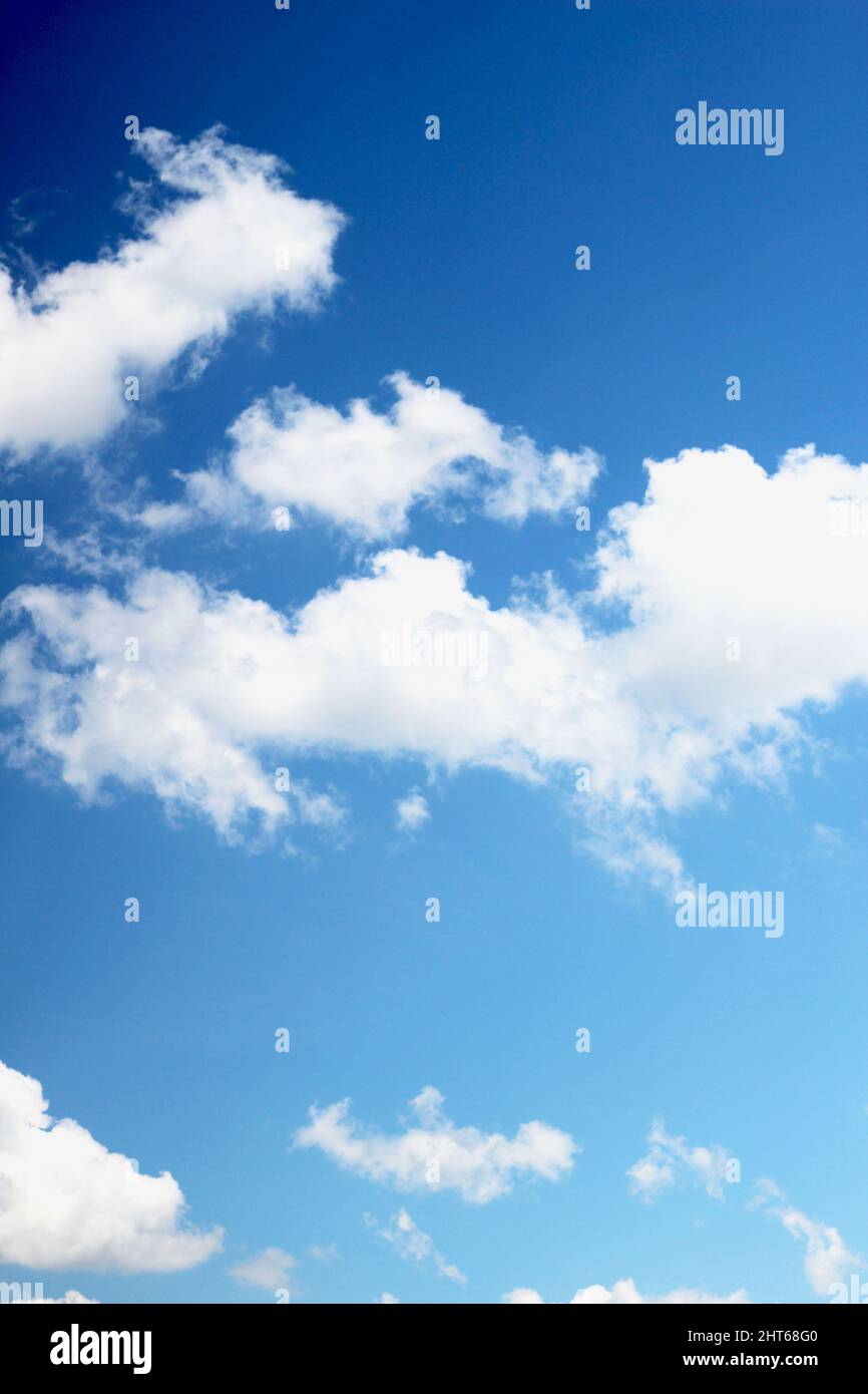 Vertical shot of the puffy clouds in the blue sky - peaceful sunny day ...