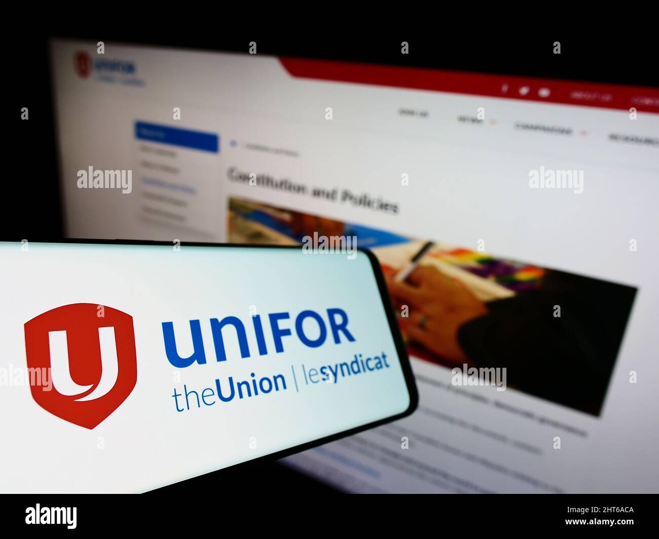 Smartphone with logo of Canadian general trade union Unifor on screen in front of website. Focus on left of phone display. Stock Photo