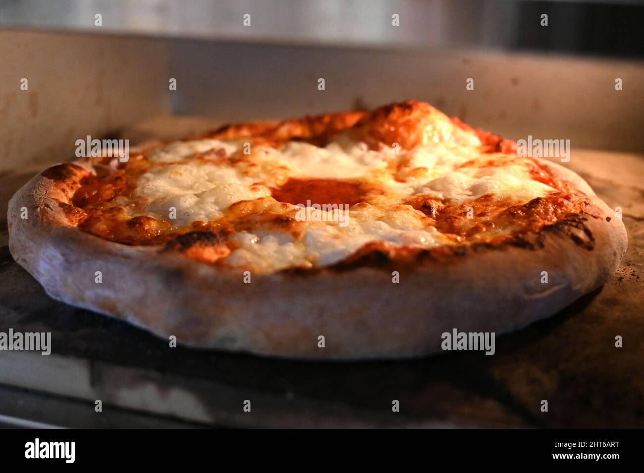 stone bake Margherita Pizza cooking in the pizza oven, Italian recipe