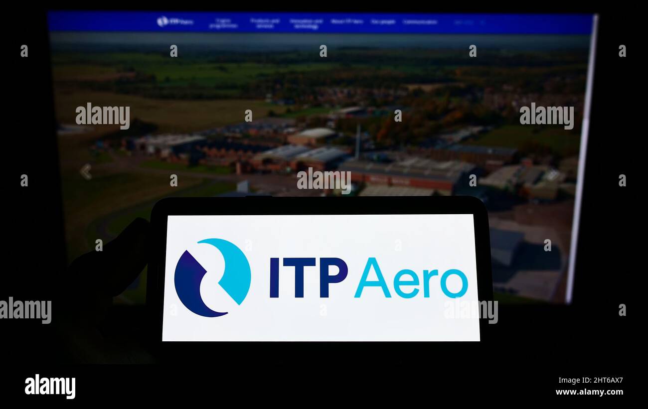 Person holding smartphone with logo of Industria de Turbo Propulsores S.A. (ITP Aero) on screen in front of website. Focus on phone display. Stock Photo