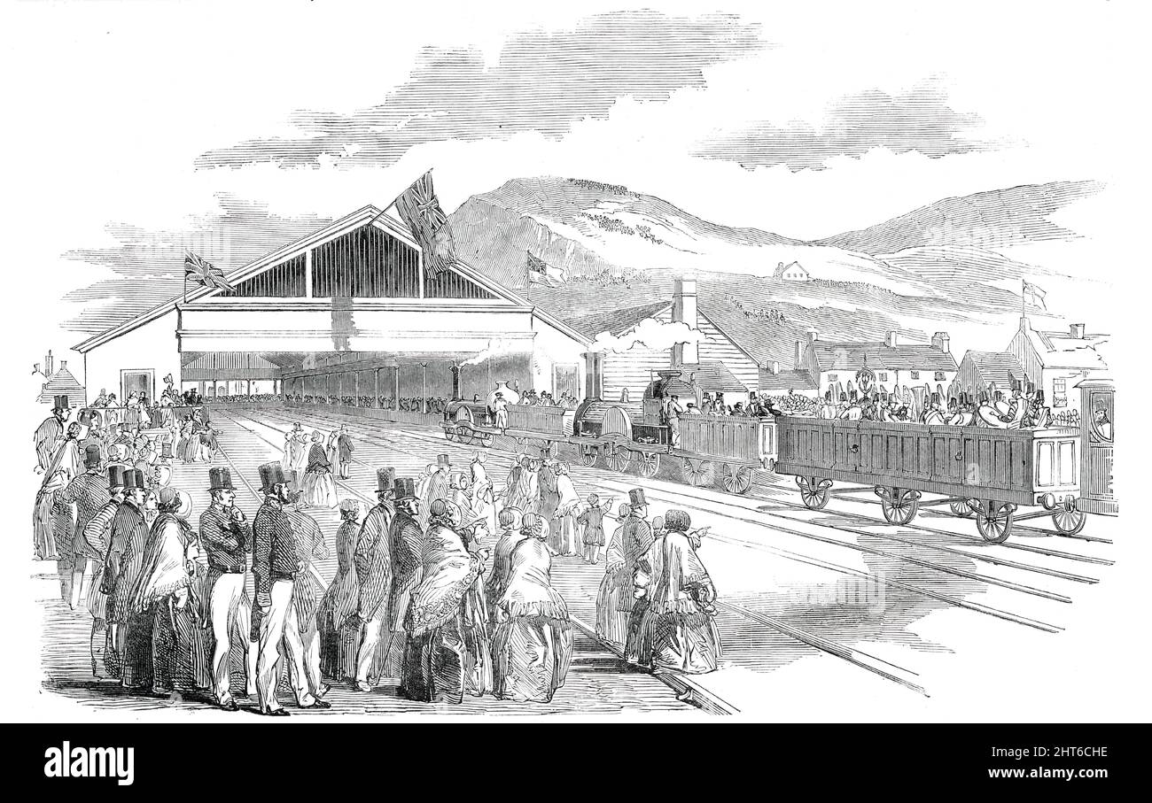 The Terminus, at Swansea, [Wales], 1850. Opening of the South Wales Railway. 'The...Railway is intended to effect a direct communication with the Great Western line at Gloucester...[it] communicates with one of the richest mineral districts in the South Wales coal basin...The arrival at Swansea took place a little after one o'clock, the engine having made the trip from Cardiff to Swansea, including stoppages, in two hours and a half. The engines, which were guided by Mr. Gooch and Mr. Martley, were studded with banners, and gaily dressed with evergreens, and came in in splendid style, amidst t Stock Photo