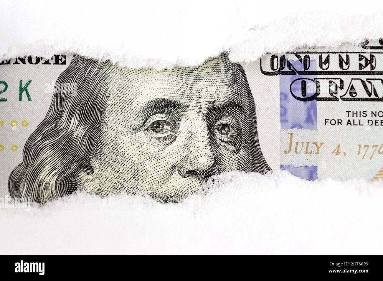 Portrait of US president Benjamin Franklin on 100 dollars banknote in torn paper hole. Hundred dollars bill fragment on macro Stock Photo
