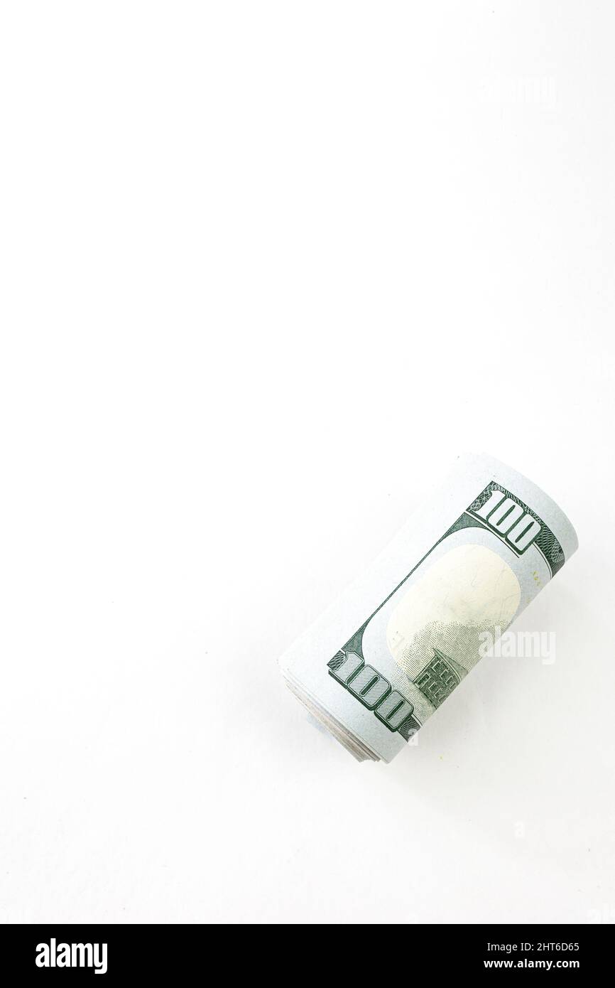 The pack of dollars is twisted into a roll. American 100 dollar banknotes made of paper placed on white background Stock Photo