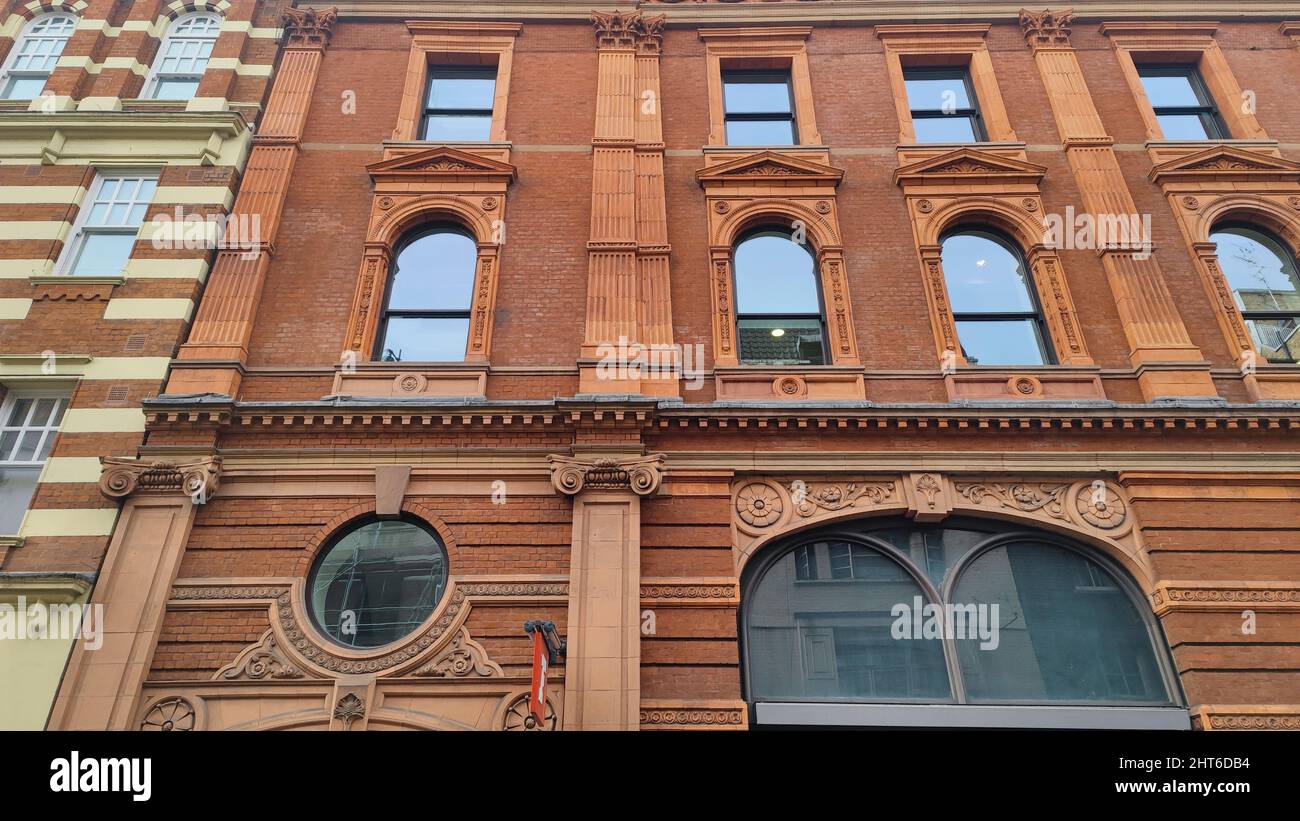 A low angle view of a facade of an old building with windows Stock ...
