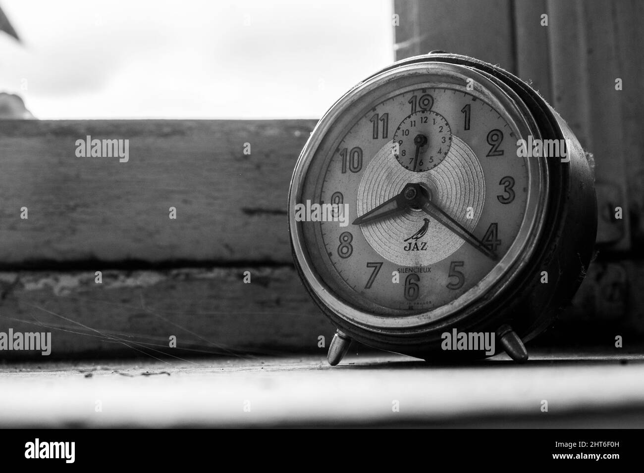 Grayscale shot of an old clock on a windowsill Stock Photo - Alamy