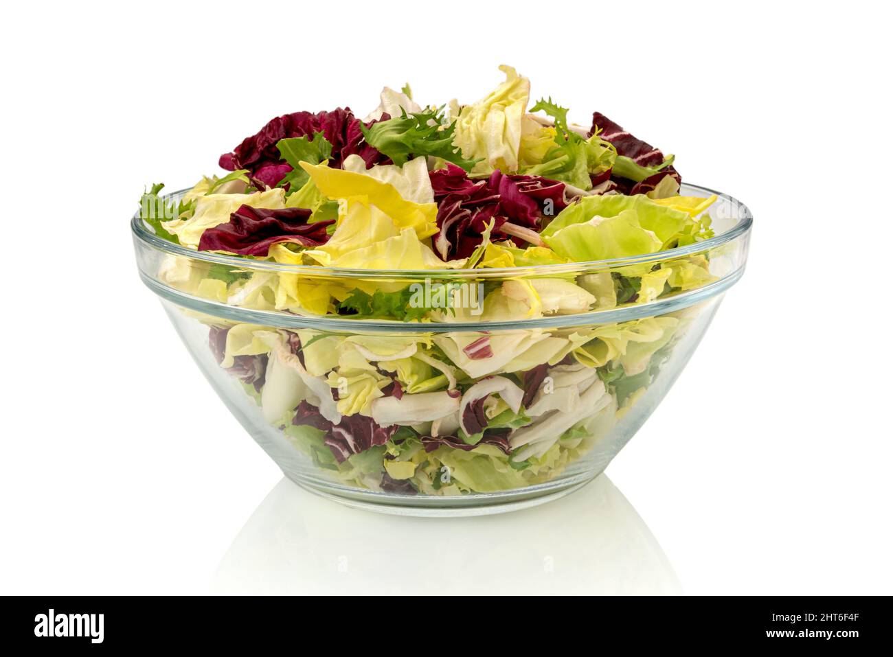 Mixed salad leaves lettuce, frisee, lamb's lettuce and radicchio in glass bowl, isolated on white, clipping path Stock Photo