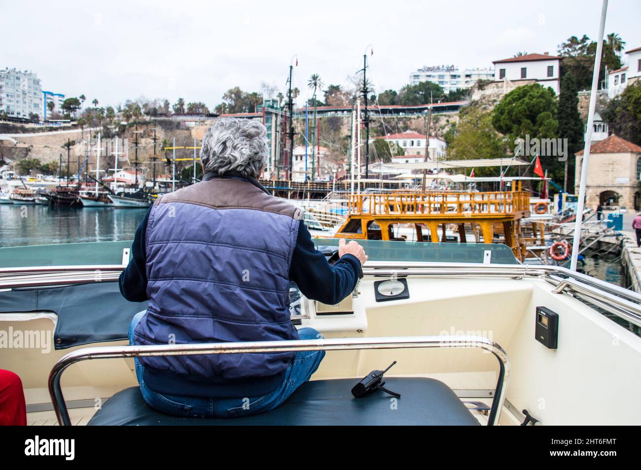 Turkish adult age 60 with grey hair operating a tourism Yacht boat Stock Photo