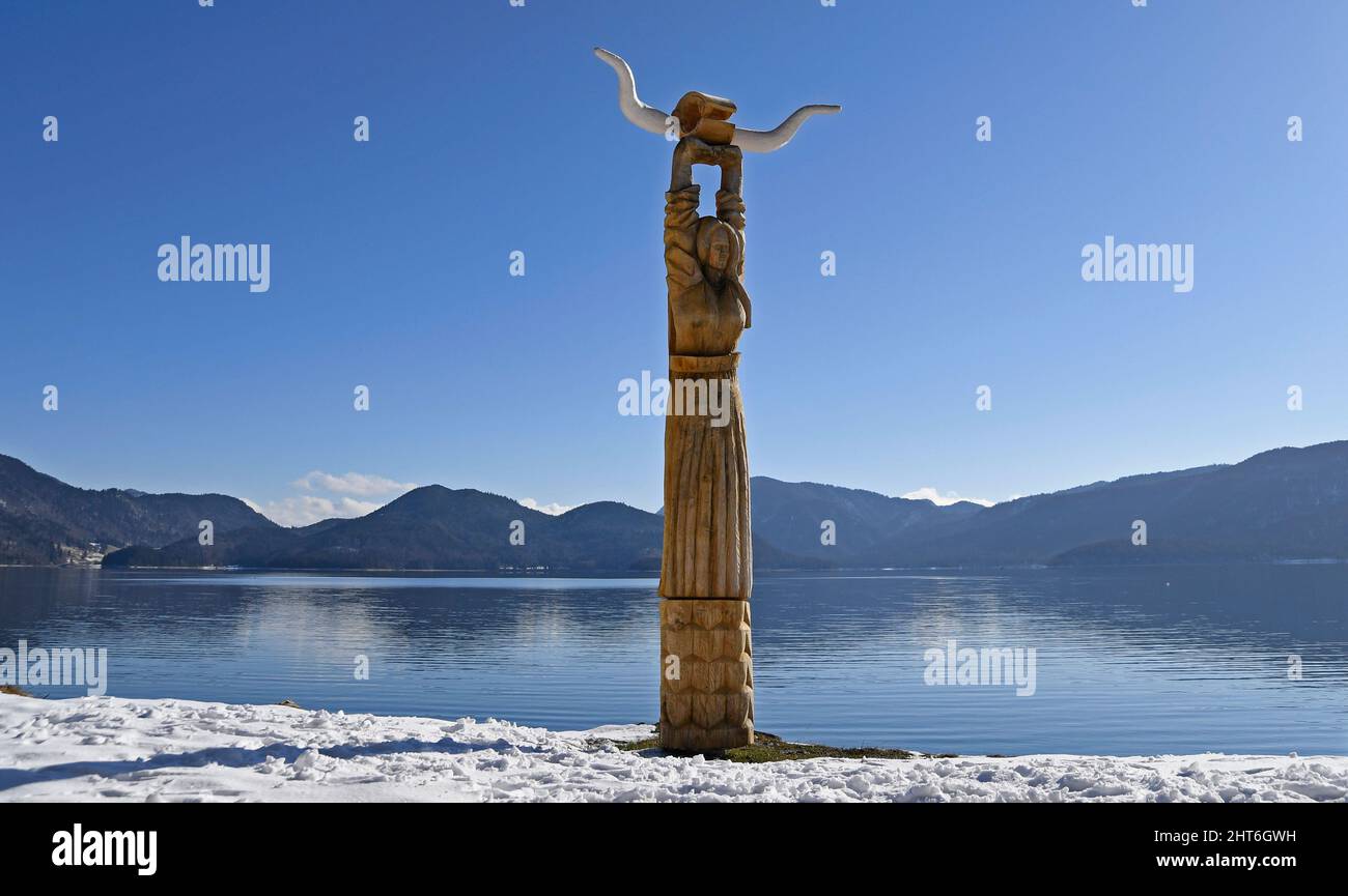 Walchensee, Germany. 27th Feb, 2022. Against a cloudless sky, on the shore of Lake Walchen, stands a wooden sculpture that is part of the Viking village where the movie 'Wickie and the Strong Men' was filmed in 2008. Credit: Uwe Lein/dpa/Alamy Live News Stock Photo