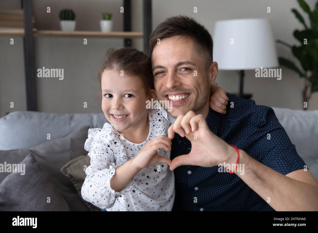 Happy small kid making heart symbol with father. Stock Photo