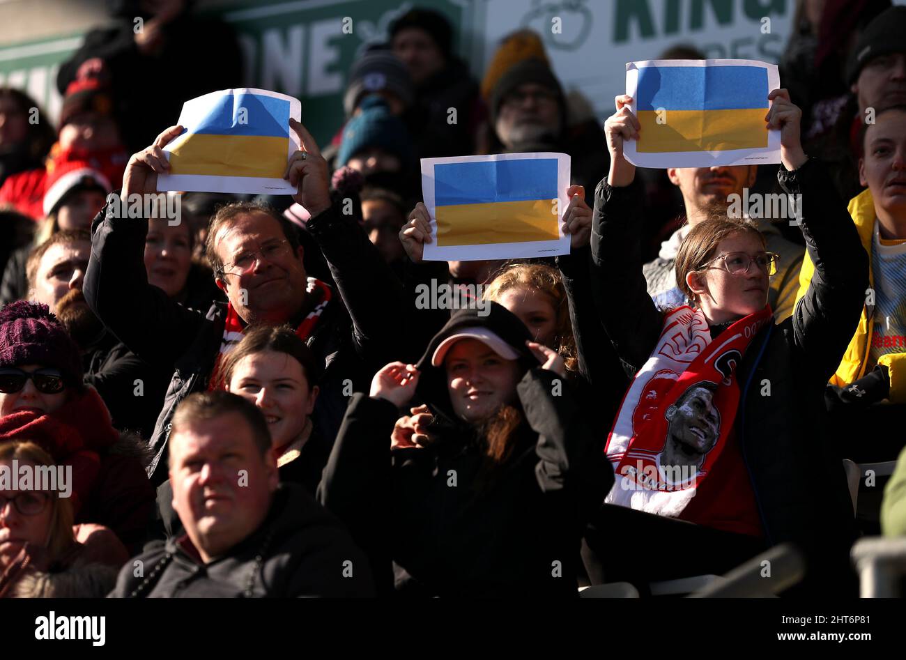 Manchester United fans hold up print outs of the flag of Ukraine to show support for them after the invasion by Russia during the Vitality Women's FA Cup fifth round match at Leigh Sports Village, Manchester. Picture date: Sunday February 27, 2022. Stock Photo