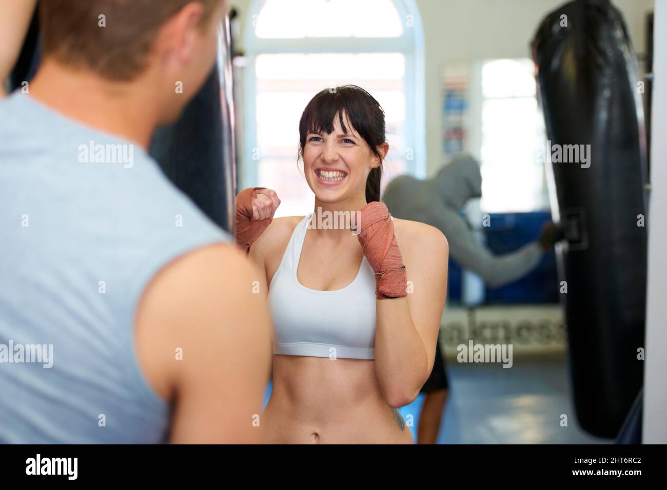 Come on. An excited young female boxer sparring with her practice partner. Stock Photo