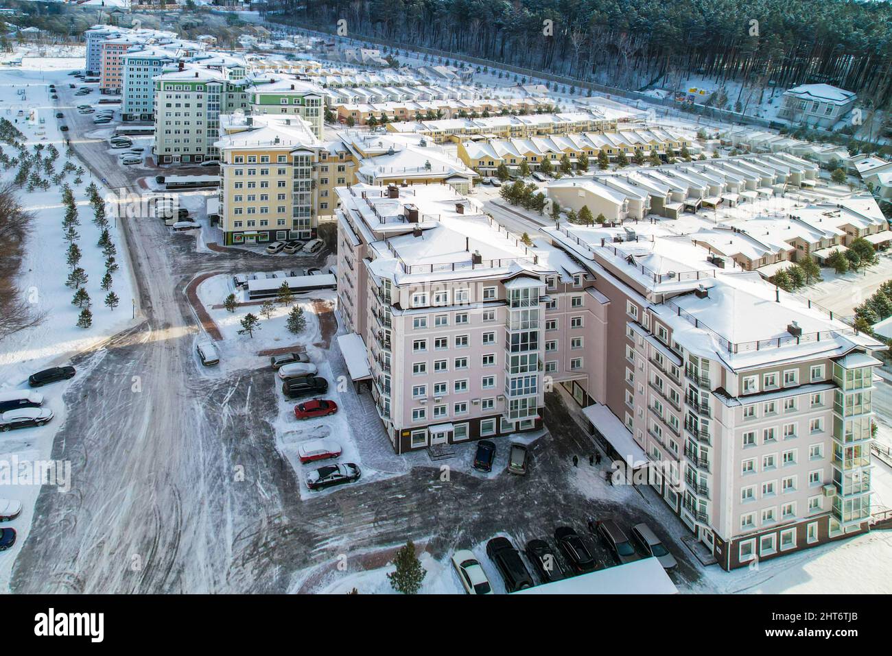Russia, Krasnoyarsk, February 19, 2022: New residential complex incom pines, elite residential area, houses and townhouses on the riverbank at the foo Stock Photo