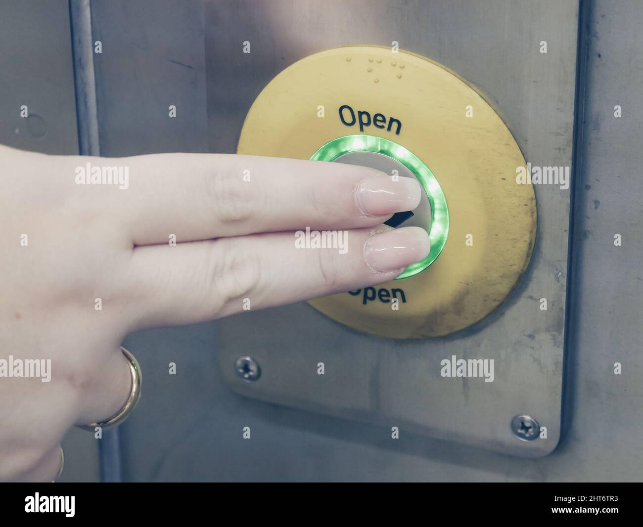 Female pushing open button at the train station Stock Photo